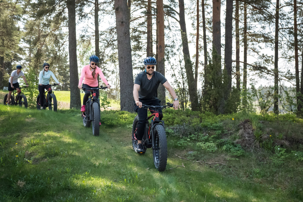 Ryhmä pyöräilemässä metsässä (Kultaranta Resort)